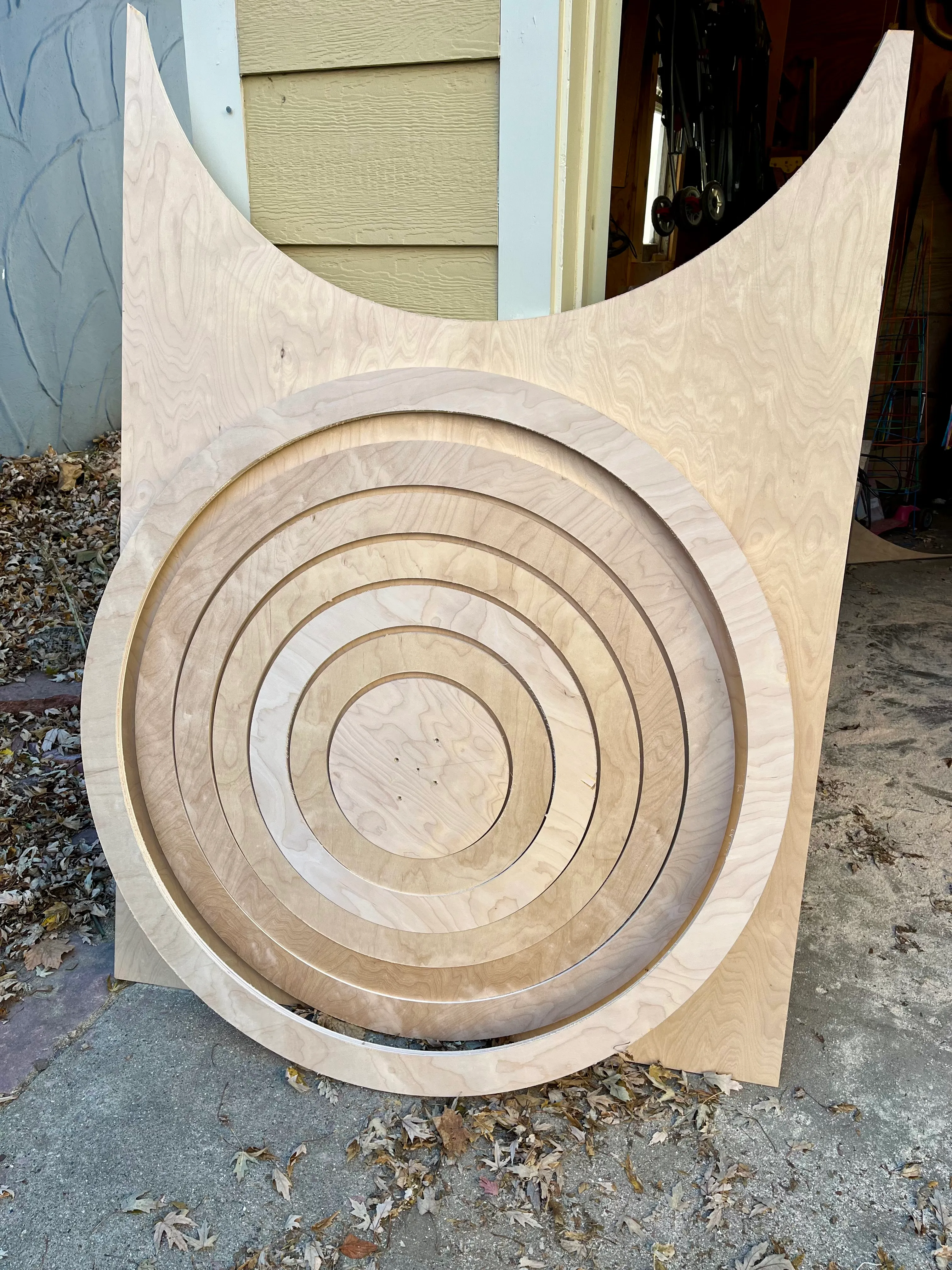 Freshly cut concentric plywood rings nested within the original sheet