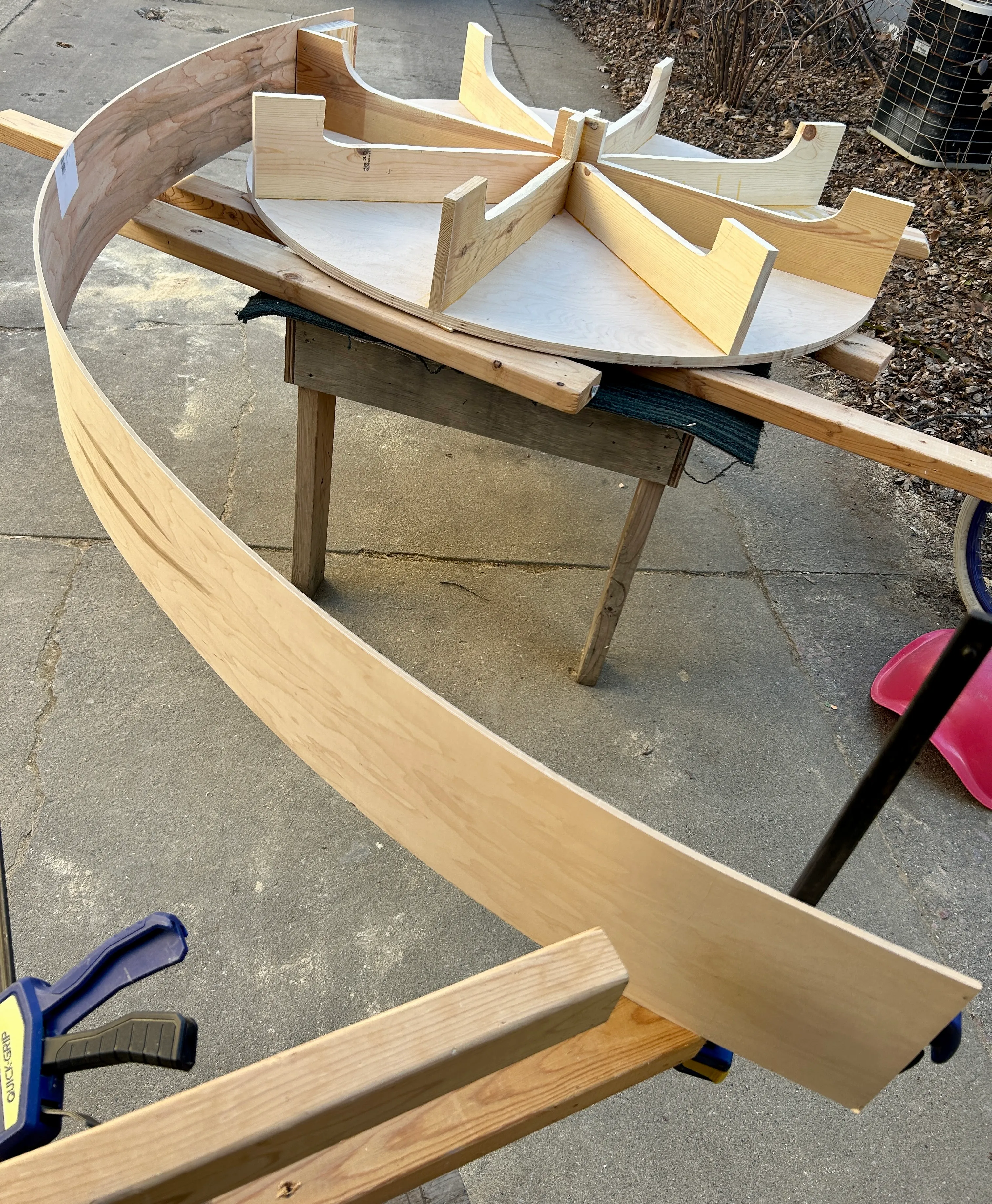Curved plywood exterior band beside the assembled base framework